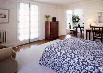 Spacious apartment bedroom at Casa Del Sol with hardwood style floor and doors to Juliette balcony in Haverford, PA